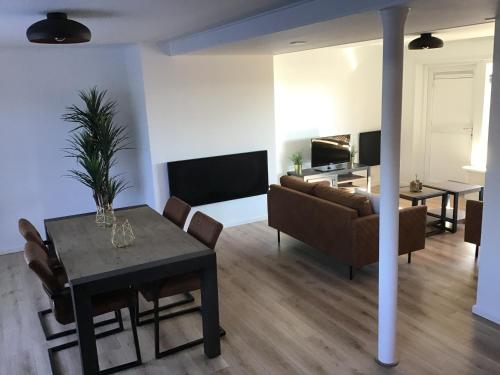 a living room with a table and a couch at VAKANTIE WONING OASE in Breskens