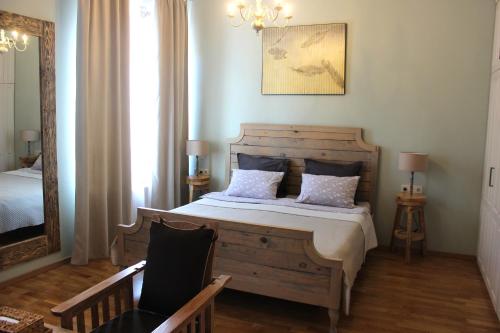 Un dormitorio con una cama, una silla y un espejo. en Leather Lane, en Tiflis