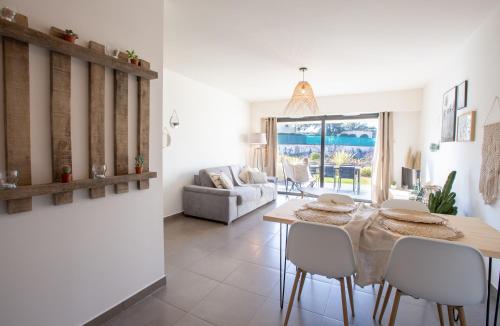 a dining room and living room with a table and chairs at T2 au coeur de Porticcio - Vue mer Imprenable ! in Grosseto-Prugna