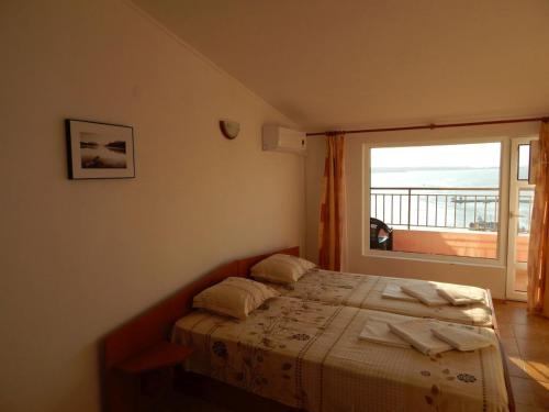 a bedroom with a bed and a large window at Tony Guest House in Sozopol