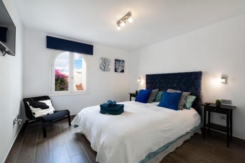 een slaapkamer met een groot bed en een stoel bij The Colors House, 629 - Private Apartment in Costa Teguise