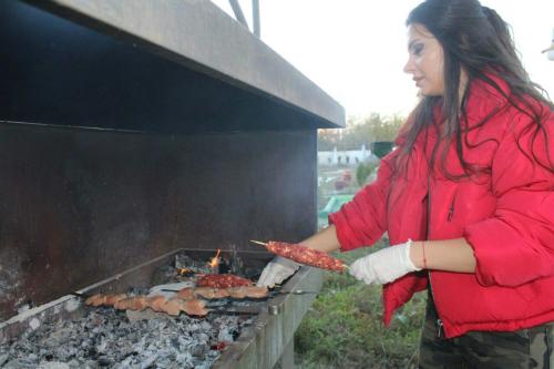 a woman is cooking food on a grill at Paradise Investment Resort in Tʼelavi