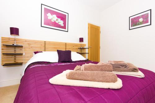 d'un lit violet avec des serviettes. dans l'établissement No. 1, Hambrough House, à Ventnor