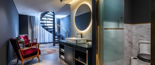 a bathroom with a sink and a spiral staircase at Moon and Chalice Boutique Hotel in Kunming
