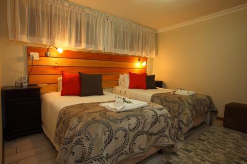 En eller flere senge i et værelse på Kaapsche Hoop Gastehuis