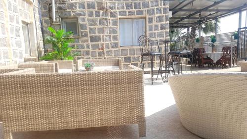 a patio with chairs and tables and a brick wall at Lake Mansion in Tiberias