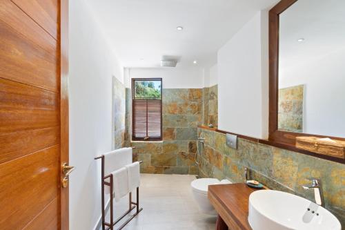 een badkamer met 2 wastafels en 2 toiletten bij The Barefoot Eco Hotel in Hanimaadhoo