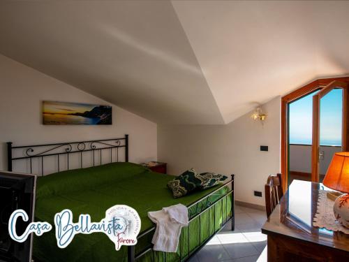a bedroom with a green bed and a window at Casa Bellavista in Furore