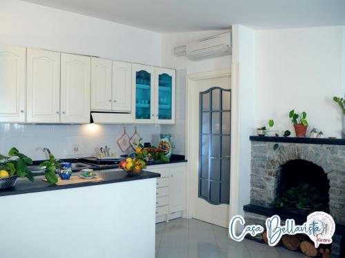 フローレにあるCasa Bellavistaの白いキャビネットと暖炉付きのキッチン