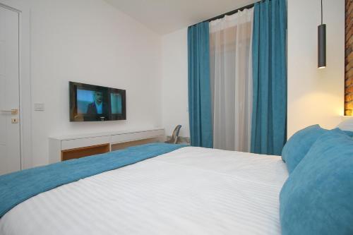 een slaapkamer met een bed en een tv aan de muur bij Elena Apartment&Spa in Zlatibor