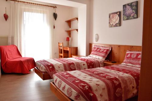 a bedroom with two beds and a window at Appartamenti Osti Sansoni Mariarosa in Andalo