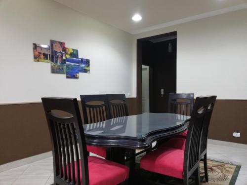 a dining room with a black table and chairs at Luxury Host -219- Dream Land in 6th Of October