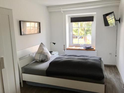 un dormitorio con una cama y una ventana en Pension Schackstedt, en Schackstedt