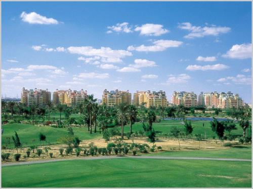 a view of a city with tall buildings and a green field at Luxury Host -219- Dream Land in 6th Of October
