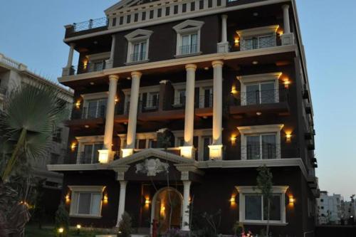 a large black building with white columns at Luxury Host -219- Dream Land in 6th Of October