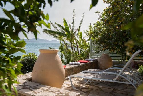 a patio with a table and chairs and a vase at Seafront apartment in Kiveri, near Nafplion. in Kivérion