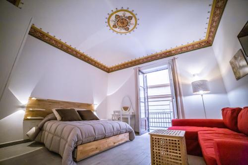 a bedroom with a bed and a red couch at B&B Opera dei Pupi in Palermo