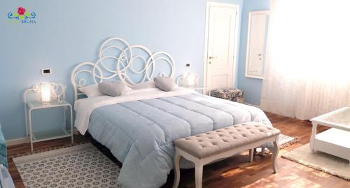 a blue bedroom with a large bed and a bench at Villa Bruna in Cesenatico