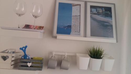 a kitchen with wine glasses and a shelf with a plant at Prima Fila in Lerici