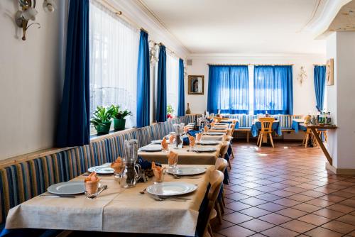 a row of tables in a restaurant with blue curtains at Villa Gemmy in Pozza di Fassa
