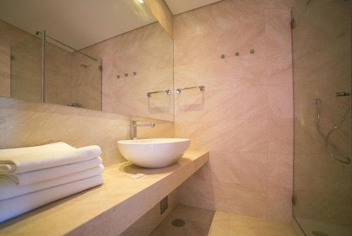 a bathroom with a sink and a glass shower at Casas Do Rio Sado - Sado River Country Retreat in Santa Margarida do Sado
