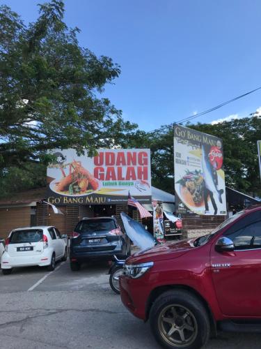 a parking lot with cars parked in front of a restaurant at PATIN GUEST HOUSE @DESA TELOK IRA, TEMERLOH PAHANG in Kampong Paya Kerinau