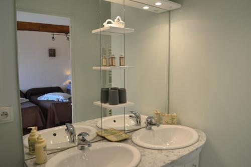 ein Badezimmer mit 2 Waschbecken und einem Spiegel in der Unterkunft LES CHAMBRES D HOTES DU LAVOIR in Restigné