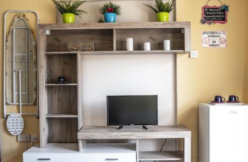 a television on a wooden shelf in a room at Lucky 2 in Paralimni