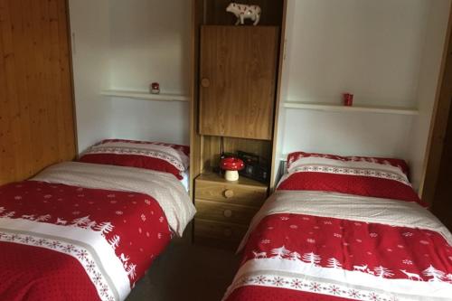 2 camas en una habitación con mantas rojas y blancas en Haus Bortis, en Niederwald