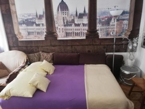 a bed in a room with a view of the city at West10 STAR City Center in Budapest