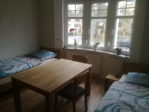 a room with two beds and a table and a window at Auestraße 94A in Glauchau