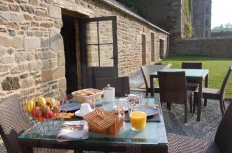 a table with food and fruit on a patio at Maison d'hôtes & Gîtes Domaine de la Garaye in Dinan