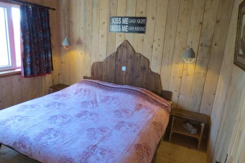 a bedroom with a bed in a wooden wall at Haus Süskewiet in Peffingen
