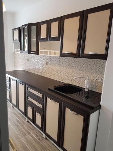 a kitchen with a black counter and a sink at Apartament Mioritza 2A in Horezu