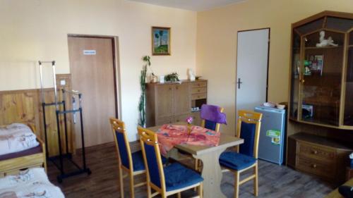 a room with a table and chairs and a kitchen at Penzion SKLAŘSKÁ HOSPODA in Chřibská