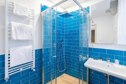 a blue tiled bathroom with a sink and a shower at Hotel San Giorgio in Venice