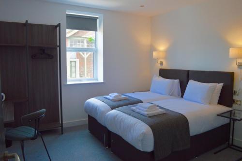 um quarto com uma cama com toalhas em Q8 Boutique Hotel em Portsmouth