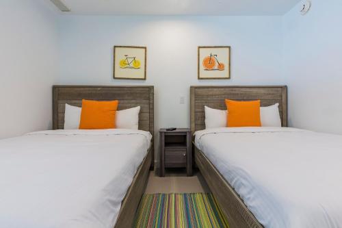 two beds sitting next to each other in a room at Azure Beach Residences in Palm-Eagle Beach