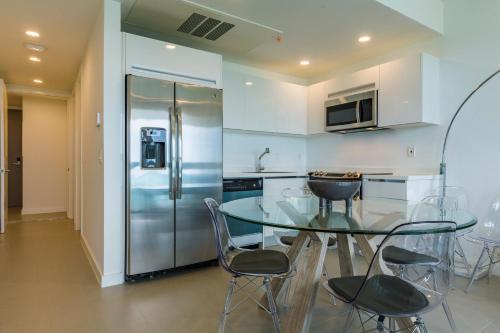 a kitchen with a glass table and a refrigerator at Azure Beach Residences in Palm-Eagle Beach