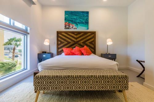 a bedroom with a large bed with red pillows at Azure Beach Residences in Palm-Eagle Beach