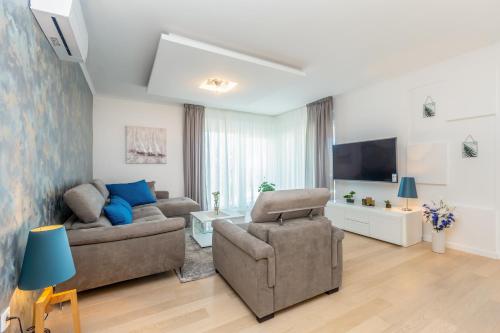 a living room with two couches and a tv at Villa Roko in Malinska