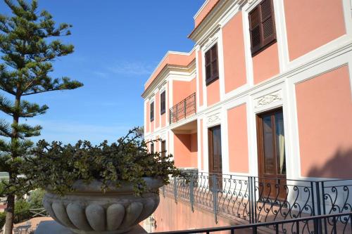a large vase with a tree in front of a building at Relais Villa Giuliana in Licata