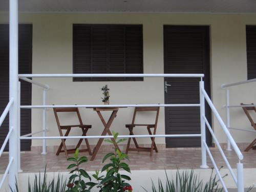 a patio with two chairs and a table on a house at Pousada Canto dos Canários in Socorro