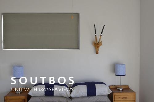 a bedroom with a bed and a sign on the wall at Soutbos & Janfrederik in Agulhas