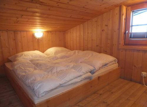 Bett in einem Holzzimmer in einer Hütte in der Unterkunft Hüttenzeit almhütte sölden in Sölden