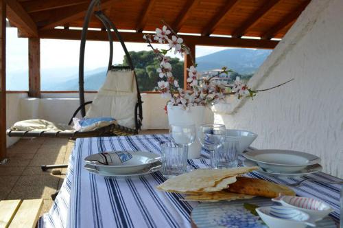 una mesa con un mantel azul y blanco con platos y gafas en Ti porto al mare Apartment IUN P7641, en Cala Gonone