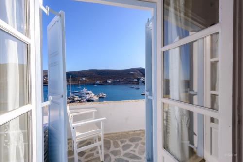 an open door to a balcony with a view of the water at Vardia Bay Studios in Karavostasi