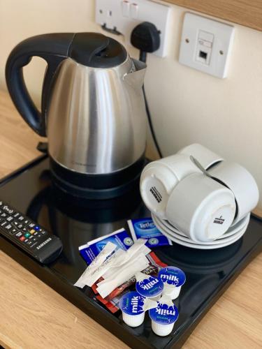 a tray with a coffee pot and a pile of food at Britannia Inn Hotel in Ilford