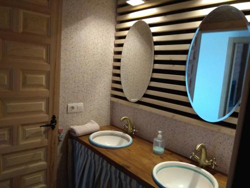 uma casa de banho com 2 lavatórios e um espelho grande em Casa de campo sierra de la demanda em Barbadillo de Herreros