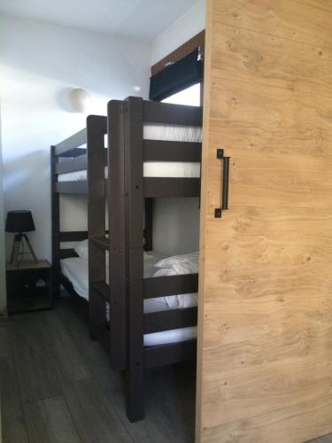 Cette chambre comprend 2 lits superposés et une porte. dans l'établissement Résidence du parc, à Briançon